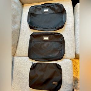 Three black CALPAK packing cubes in 3 different sizes
